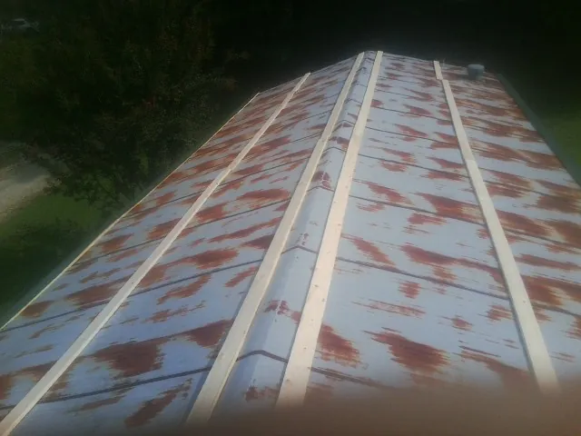 Rusted metal roof panels with new wood purlins before replacement — Storm Damage Roof Repair in Falls City by Roofing Brothers