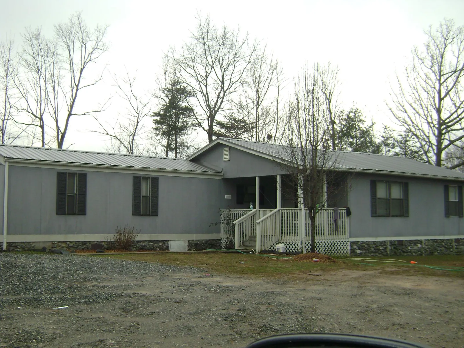 Metal roof over a manufactured home with a covered front porch in Falls City