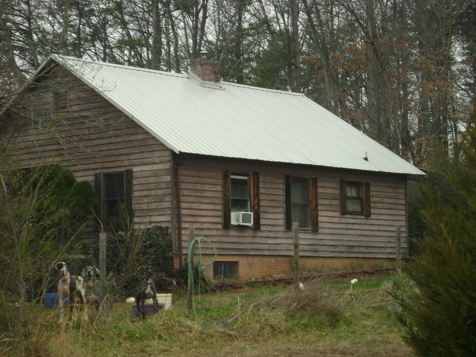 White metal roof on an old wood sided farmhouse, from a Metal Roof Installation job in Falls City